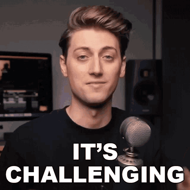 a man standing in front of a microphone with the words it 's challenging