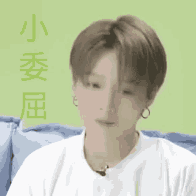 a person wearing a white shirt and earrings is sitting on a couch