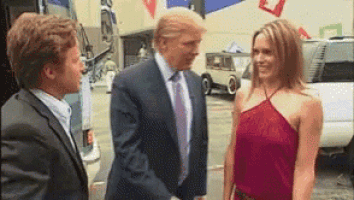 a man in a suit and tie is shaking hands with a woman in a red top