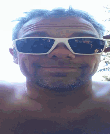 a man with a beard wearing white sunglasses