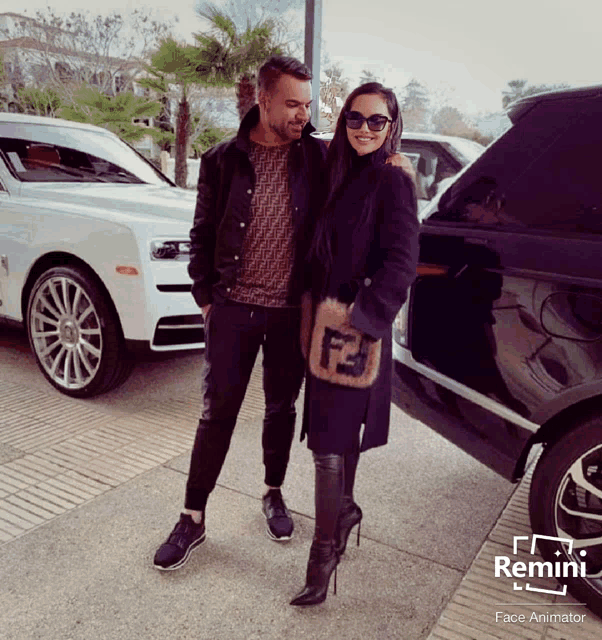 a man and a woman are posing for a picture in front of a car that says remini on it