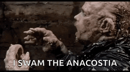 a man with a beard is eating a piece of meat and says `` i swam the anacostia '' .