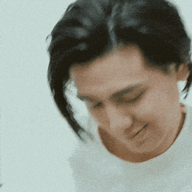 a close up of a person 's face with a white shirt on