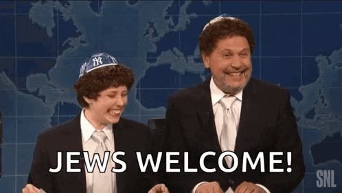 two men are sitting next to each other and one of them is wearing a yarmulke and says jews welcome