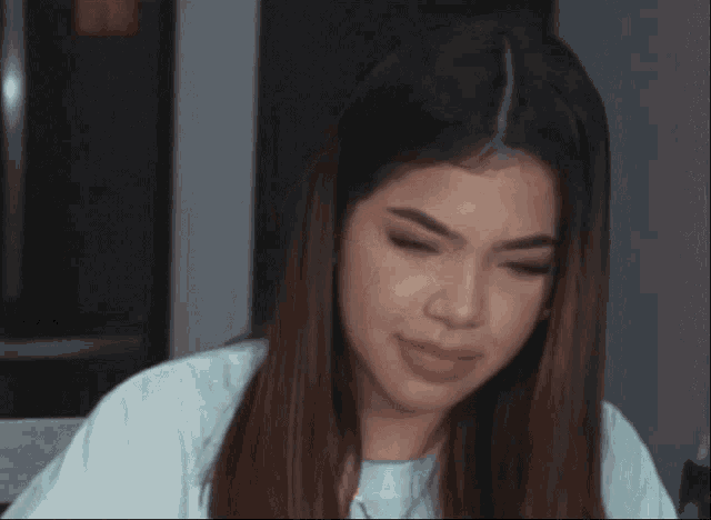 a woman with long brown hair is making a face