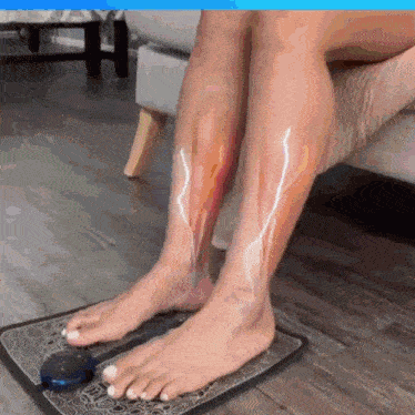 a woman is sitting on a couch with her feet on a mat with a lightning bolt on her leg .