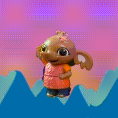 a toy elephant with a flower on her head is standing on a cliff .