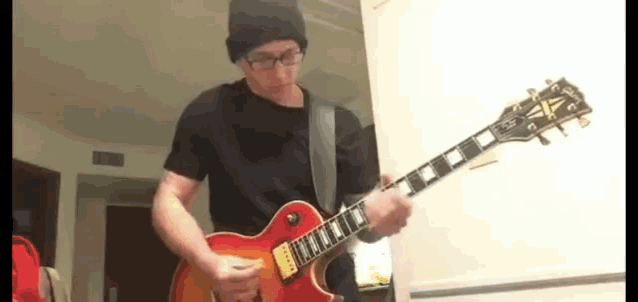 a man in a black shirt is playing an electric guitar .