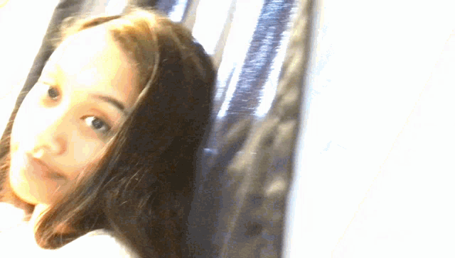 a girl taking a picture of herself in front of a window