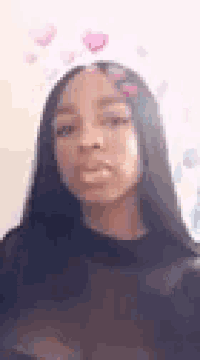 a woman with long black hair is wearing a heart shaped filter on her face .