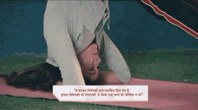 a woman laying on her back on a yoga mat with a caption in hindi