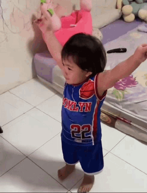 a little boy wearing a brooklyn jersey with the number 22