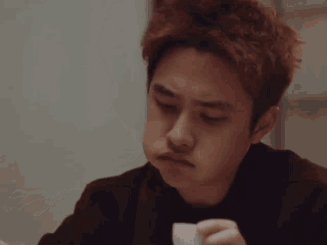 a man is eating something with chopsticks and looking at something