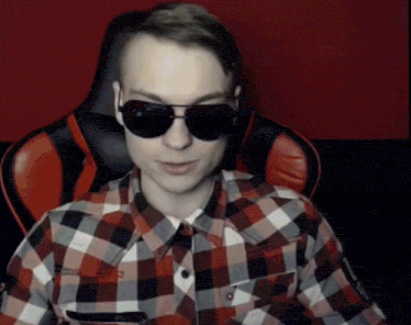 a man wearing sunglasses and a plaid shirt is sitting in a red chair