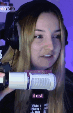 a woman is wearing headphones and holding a microphone with the word il est visible