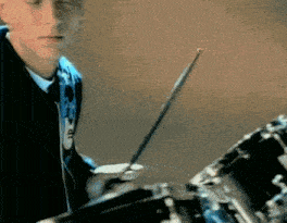 a man is playing a drum set with a drum stick that says ' a ' on it