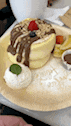 a close up of a pancake on a plate with whipped cream .