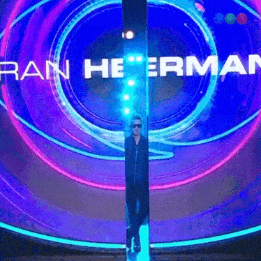 a man is standing in front of a sign that says rain heerman