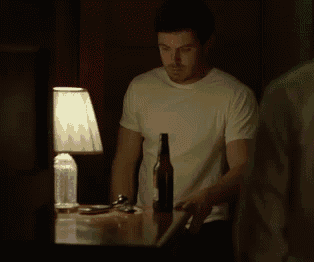 a man in a white shirt is standing next to a lamp and a bottle