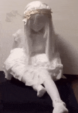 a white doll is sitting on a black mat