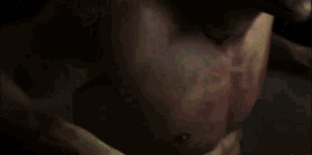 a close up of a man 's torso with a few spots of blood on it