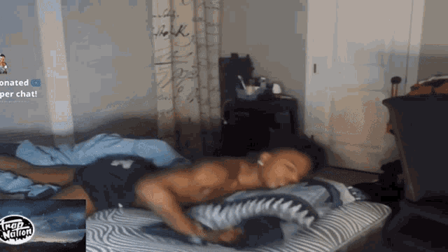 a man laying on a bed in front of a trap nation advertisement