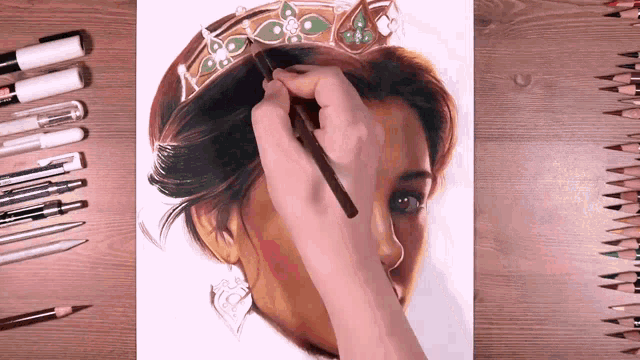 a person is drawing a woman wearing a crown on a piece of paper