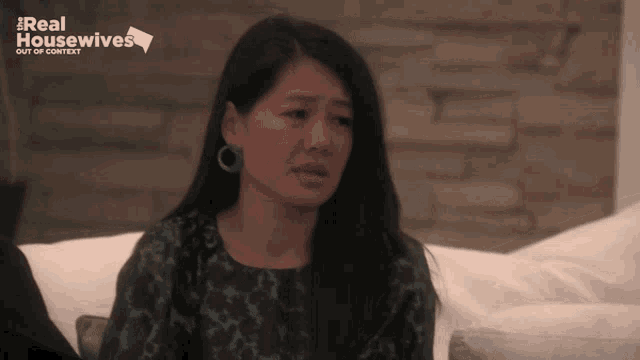 a woman sitting on a couch with the words real housewives out of context