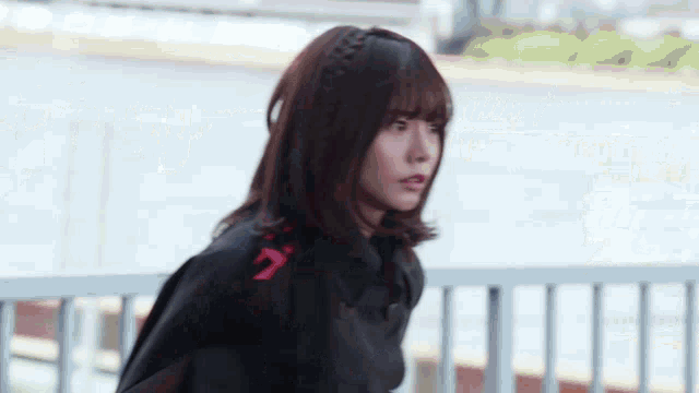 a woman wearing a black jacket with the number 7 on the back