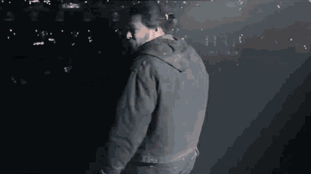 a man in a dirty jacket is standing on a stage .