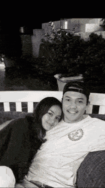 a man and a woman are posing for a picture on a couch