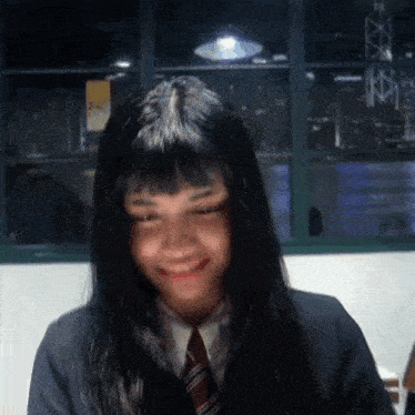 a girl with long black hair is wearing a suit and tie
