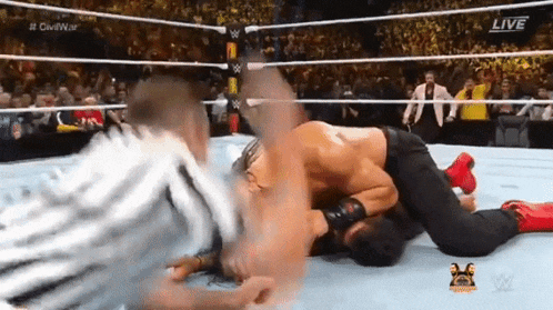two men are wrestling in a wrestling ring with the words live on the bottom