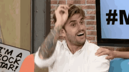 a man in a white shirt has a tattoo on his arm that says i 'm a rockstar