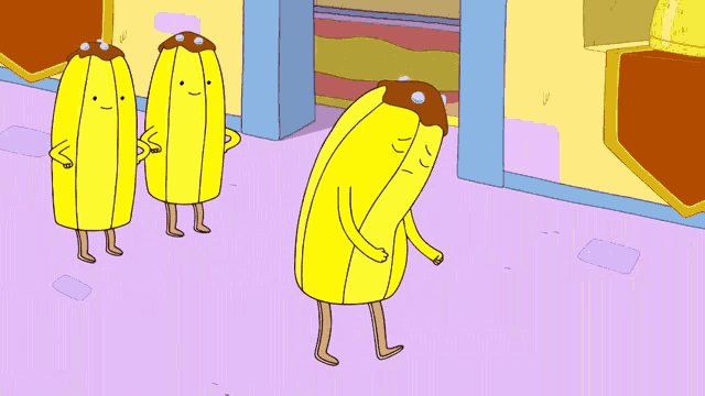 three bananas with chocolate icing on their heads are standing in front of a building