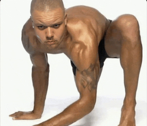 a man with a tattoo on his arm is doing push ups on his hands