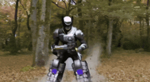 a man in a robotic suit is standing in the woods
