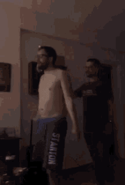 a shirtless man in blue shorts that say stanley on them