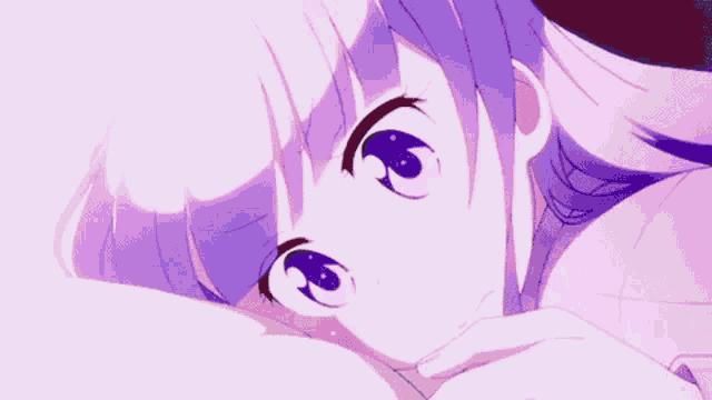 a close up of a girl with purple hair and blue eyes laying down .