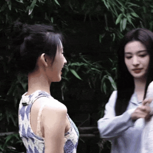 two women are standing next to each other talking