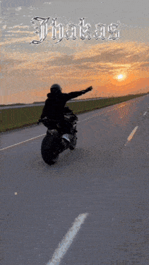 a man is riding a motorcycle down a road with the word thakas on the top