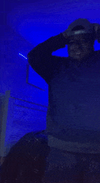 a person 's back is shown in a dark room with blue lights