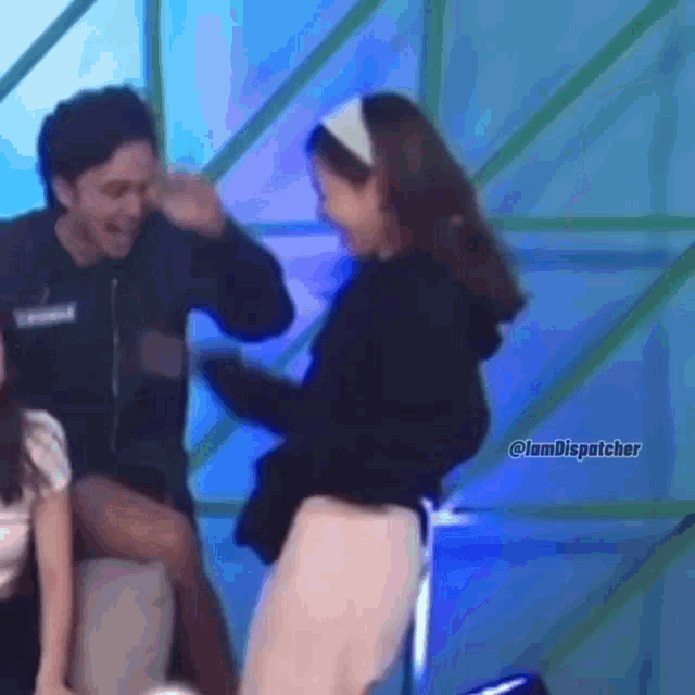 a man and a woman are dancing on a stage and the woman is wearing a white headband .