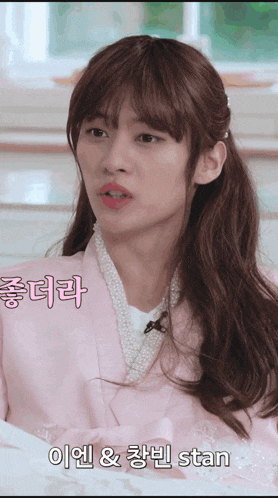 a woman in a pink kimono with pearls around her neck says stan