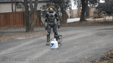 a person in a robot costume is standing next to a propane tank