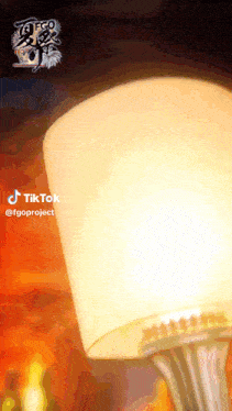 a tiktok video of a lamp with a candle in the background