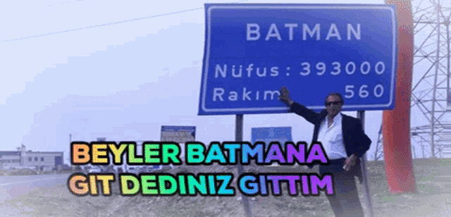 a man is standing in front of a sign that says batman