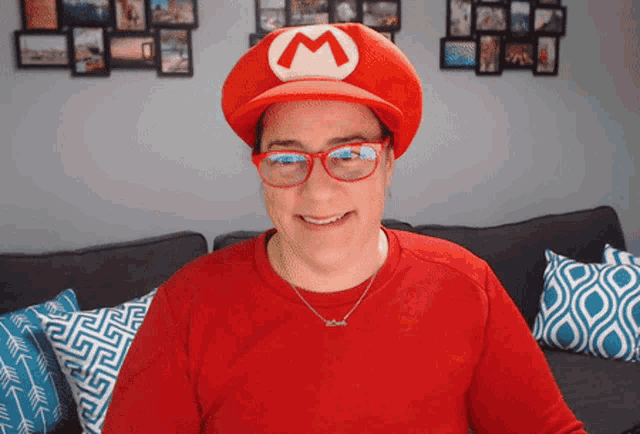 a woman wearing a mario hat and glasses smiles