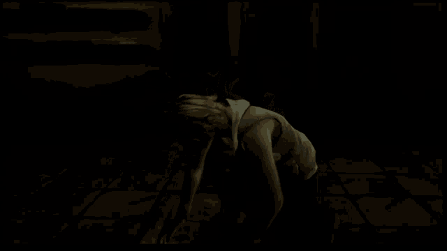 a woman is holding a gun in her hand in a dark room