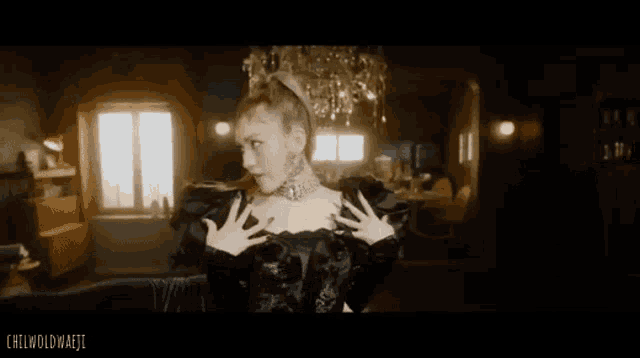 a woman in a black dress is standing in a living room .